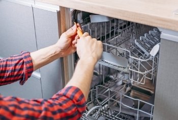 technician repairing a dishwasher