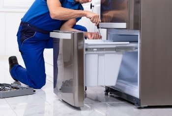 technician repairing a fridge