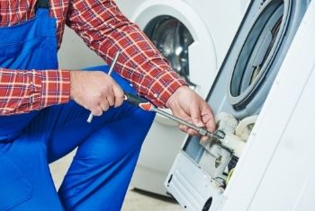 technician repairing washer appliance